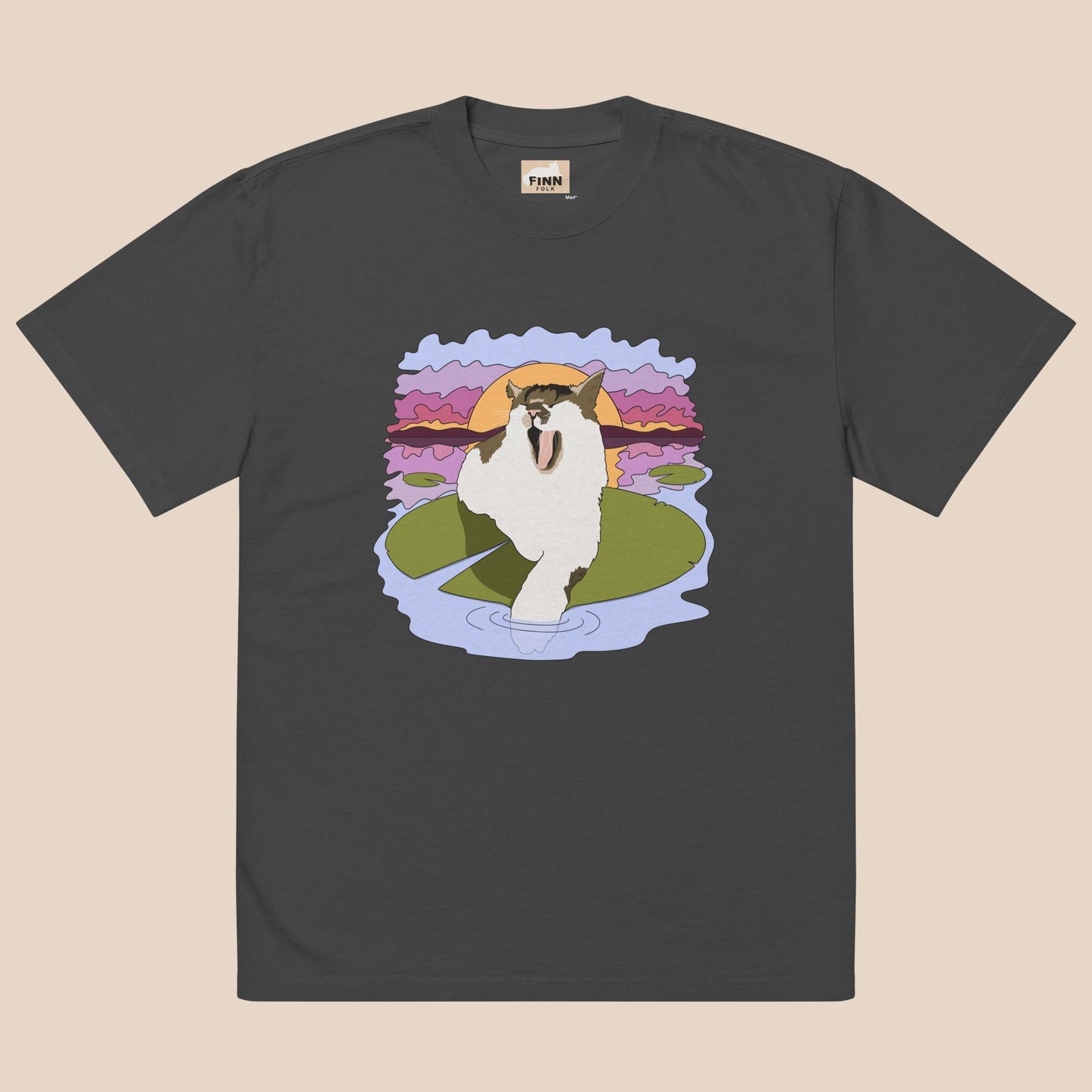 Black t-shirt with a cartoon cat on a lily pad design against a beige background