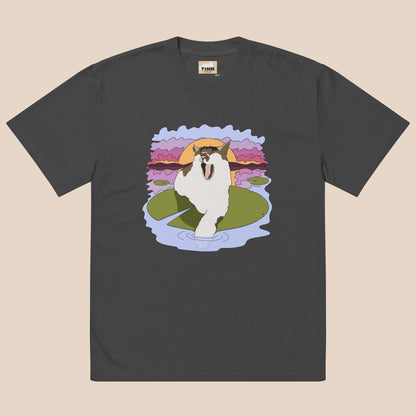 Black t-shirt with a cartoon cat on a lily pad design against a beige background