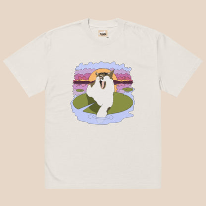 White t-shirt with a graphic of a cat on a lily pad and sunset design.