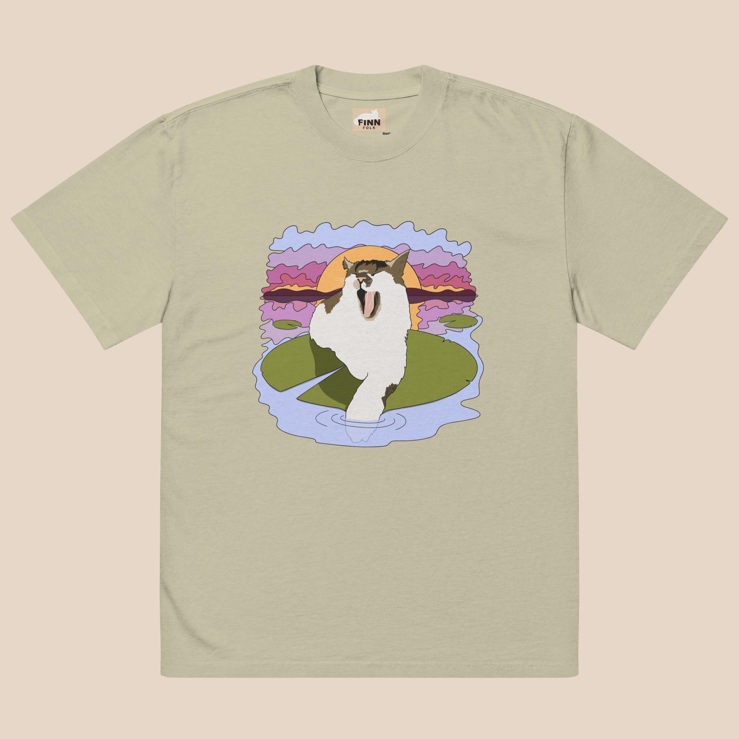T-shirt with a graphic of a cat on a lily pad against a sunset background